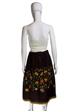 Load image into Gallery viewer, Mannequin wearing a white top and brown skirt with floral embroidery against a plain wall.

