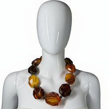 Load image into Gallery viewer, Mannequin wearing a necklace with amber-colored beads on a white background
