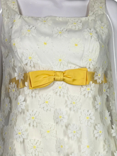 Load image into Gallery viewer, White dress with yellow floral pattern and yellow bow on a mannequin

