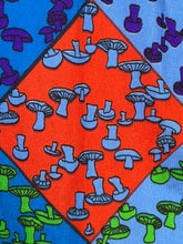 Load image into Gallery viewer, Patterned fabric with blue, purple, and green mushrooms on a red and orange background
