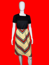 Load image into Gallery viewer, Mannequin wearing a set featuring a black top and a chevron skirt
