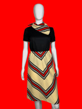 Load image into Gallery viewer, Mannequin wearing a set featuring a black top and a chevron skirt as well as a matching scarf
