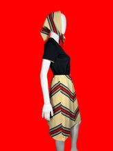 Load image into Gallery viewer, Mannequin wearing a set featuring a black top and a chevron skirt as well as a matching scarf
