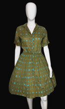 Load image into Gallery viewer, Green and blue patterned dress on a mannequin 
