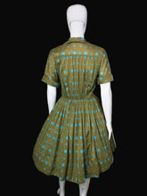Load image into Gallery viewer, Green and blue patterned dress on a mannequin 
