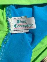 Load image into Gallery viewer, Close-up of a clothing tag on a blue and green fabric reading "Point Conception"
