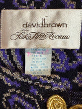 Load image into Gallery viewer, Clothing label with 'David Lawrence' branding on a patterned fabric background.
