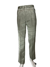 Load image into Gallery viewer, A pair of trousers with a plaid pattern, displayed on a white mannequin leg against a white wall.
