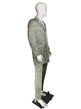 Load image into Gallery viewer, A men's two-piece suit displayed on a white mannequin, featuring a windowpane plaid pattern. The suit includes a button-up jacket and matching trousers, shown in a side profile.
