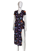 Load image into Gallery viewer, A short-sleeve romper with a  wrap skirt  in a multicolor cloud pattern on a black background, displayed on a white mannequin,
