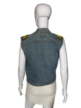 Load image into Gallery viewer, A sleeveless denim vest with yellow and black striped shoulder epaulets, shown from the back on a white mannequin.
