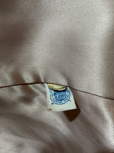 Load image into Gallery viewer, Close-up of a beige satin fabric with a visible union label.
