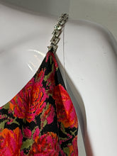 Load image into Gallery viewer, A close-up of a garment with a vibrant floral pattern in pink, orange, and green on a black background, attached to a silver rhinestone embellished strap
