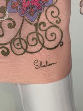 Load image into Gallery viewer, A close-up of a pink fabric with a black ornate scroll pattern, a partial floral motif in pink and purple, and the cursive brand name 'Shaheen' printed on it.

