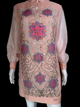 Load image into Gallery viewer, A pink embroidered tunic dress shown on a white mannequin. The dress features long sheer sleeves, a mandarin collar, and intricate floral and scroll embroidery in pink, purple, and gold.
