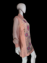 Load image into Gallery viewer, A pink embroidered tunic dress shown on a white mannequin. The dress features long sheer sleeves, a mandarin collar, and intricate floral and scroll embroidery in pink, purple, and gold.
