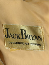 Load image into Gallery viewer, Close-up of a beige fabric garment label reading 'Jack Bryan' and 'Designed by Dupuis' in black text.
