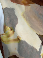Load image into Gallery viewer, A close-up of a patterned fabric in beige, gray, brown, and pale yellow tones showing some small stains and discoloration.
