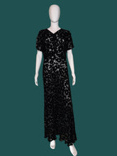 Load image into Gallery viewer, A black floral print silk burn out maxi dress displayed on a white mannequin.
