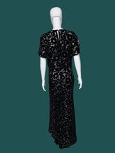 Load image into Gallery viewer, A black floral print silk burn out maxi dress displayed on a white mannequin.

