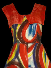 Load image into Gallery viewer, A close-up of a dress featuring a bold abstract print with red, orange, blue, yellow, brown, and white brushstroke patterns.
