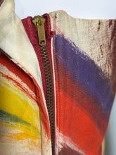 Load image into Gallery viewer, Close up of a metal zipper on a colorful pattern featuring a bold abstract swirl pattern in red, blue, yellow, and white.
