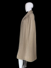Load image into Gallery viewer, A beige ribbed knit cape with a draped collar and layered hem, displayed on a white mannequin.
