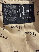 Load image into Gallery viewer, Close-up of a beige fabric label with black script reading 'Pucci' and a black sewn-in brand patch showing 'Pucci Chicago' and an embroidered crest.
