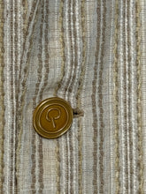 Load image into Gallery viewer, A close-up of a round gold-toned button with a stylized letter 'P' engraved in the center, resting on a textured beige and gray striped woven fabric.
