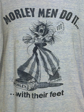 Load image into Gallery viewer, Close-up of a heather blue ringer t-shirt with a navy graphic of a man with guitar pedals for feet and the text "MORLEY MEN DO IT...with their feet"
