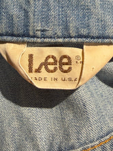 Load image into Gallery viewer, Close-up of a denim garment showing the inner neck label with the embroidered Lee brand name and 'MADE IN U.S.A.' text.
