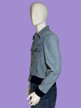 Load image into Gallery viewer, A light blue denim jacket with dark navy ribbed trim at the collar, cuffs, and hem, displayed on a white mannequin.
