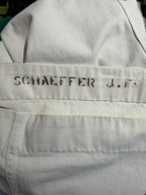 Load image into Gallery viewer, Close-up of off-white canvas pants showing the embroidered name 'SCHAEFFER J.F.' on the waistband.
