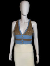 Load image into Gallery viewer, A sleeveless knit cardigan top displayed on a white mannequin. The top features a color block brown light blue knit with a button closure.
