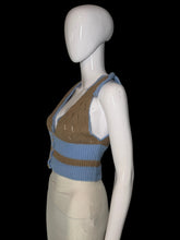 Load image into Gallery viewer, A sleeveless knit cardigan top displayed on a white mannequin. The top features a color block brown light blue knit with a button closure.
