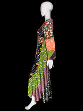Load image into Gallery viewer, A long-sleeved patchwork maxi dress displayed on a mannequin. The dress features a vibrant multicolor patchwork design with various patterns including houndstooth, polka dots, florals, and plaid in orange, green, pink, black, white, and purple.
