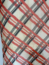 Load image into Gallery viewer, A close-up of a small stain on plaid fabric pattern featuring diagonal stripes in red, black, and thin gray lines on a warm cream background.
