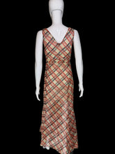 Load image into Gallery viewer, A 1930's sleeveless V-neck midi dress with a diagonal plaid pattern in red and black on a beige base on a white mannequin.
