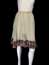 Load image into Gallery viewer, A sheer beige tulle skirt with a ruffled hem featuring a burgundy and brown floral pattern, displayed on a white mannequin.

