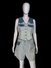 Load image into Gallery viewer, A sleeveless denim vest and matching shorts set displayed on a white mannequin against a plain indoor wall. The vest has blue denim shoulder panels and chest pockets with front buttons, and the shorts are light-wash denim with blue pocket accents.
