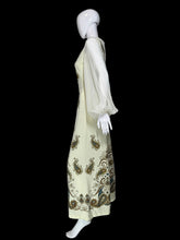 Load image into Gallery viewer, A cream-colored jumpsuit with a brown and gold paisley pattern, displayed on a white mannequin.
