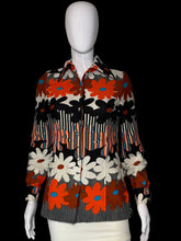 Load image into Gallery viewer, A long-sleeve button-up shirt with a bold retro floral and striped pattern in orange, black, white, and gray, displayed on a white mannequin.
