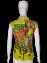 Load image into Gallery viewer, A sleeveless blouse displayed on a white mannequin, showing the back view. The vest features a vibrant, multicolored floral and botanical print with a yellow-green base and detailed illustrations of flowers, leaves, and a woman in a landscape.
