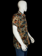 Load image into Gallery viewer, A short-sleeve button-up shirt displayed on a white mannequin. The shirt features a dense collage print of magazine cover illustrations in a multicolor palette of blue, red, beige, and brown.
