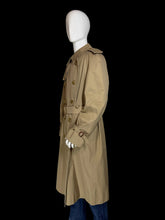 Load image into Gallery viewer, The side view of a classic Burberry double-breasted trench coat in khaki beige, shown on a white mannequin. The coat features a belted waist, shoulder epaulets, and button closures.
