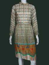 Load image into Gallery viewer, A long-sleeve midi dress with a pleated texture, featuring a beige base with colorful horizontal stripes and a vibrant geometric pattern near the hem, displayed on a white mannequin.

