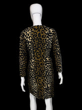 Load image into Gallery viewer, A long-sleeve leopard-print dress displayed on a white mannequin. The dress features a bold black and tan/gold animal print pattern with a button-up front and side pockets.
