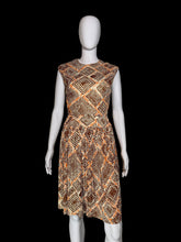 Load image into Gallery viewer, A sleeveless fit-and-flare dress with a geometric diamond pattern in orange, brown, and beige, displayed on a white mannequin.
