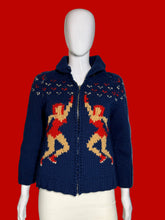 Load image into Gallery viewer, A navy blue knit zip-up cardigan sweater with a hood, featuring two large red and beige dancer motifs on the front, displayed on a white mannequin.
