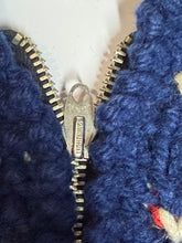 Load image into Gallery viewer, Close-up of a dark blue textured knit garment with a silver metal zipper and pull tab.
